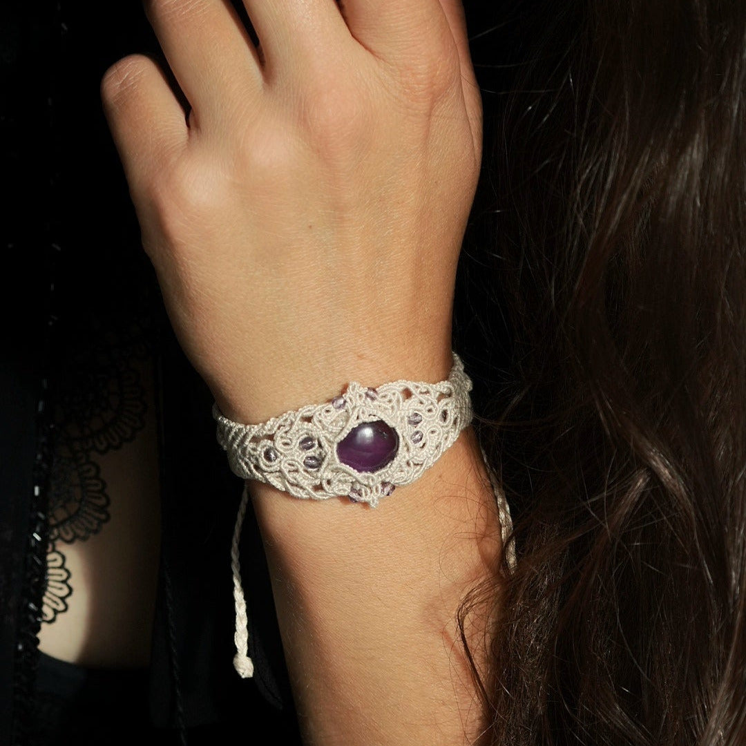 Bracelet manchette en améthyste violette, bijou wicca artisanal en micro macramé, porté avec dentelle noire dans une ambiance sorcière mystique. Coton et Astrance