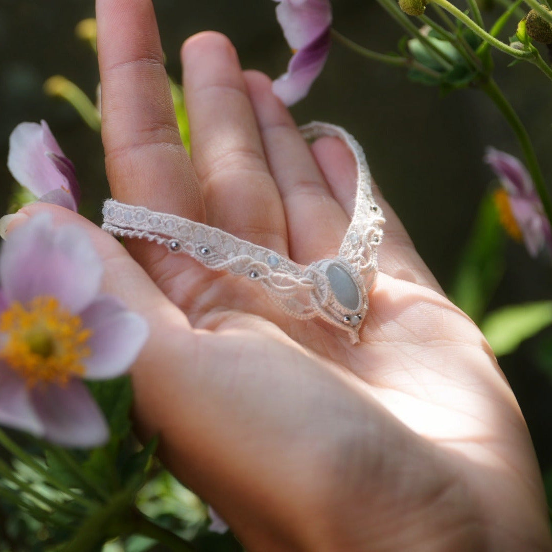 Bracelet de cheville elfique en aigue-marine porté sur une mariée pieds nus, bijou bohème sirène en coton écru réglable. Coton et Astrance