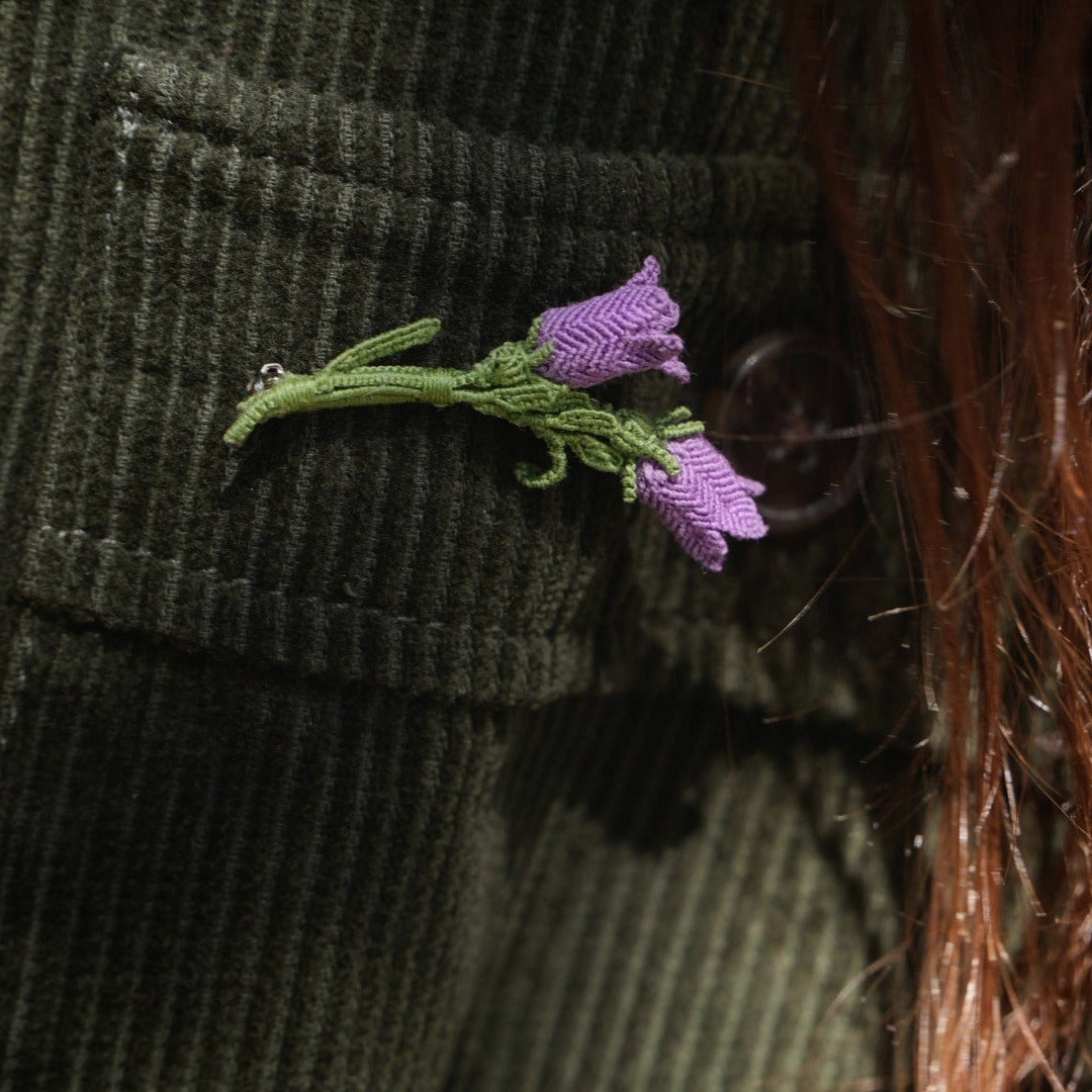 Bijou unisexe en micro macramé. Accessoire de mode inspiré de la nature et des fleurs sauvages d'été. Broche composée de deux campanules violettes avec feuille ciselée. Support de broche en laiton rhodié argenté fin avec cliquet de sécurité à tourner. Accessoire elfique, féérique pour veste, sac ou chapeau. Parfait en Boutonnière de mariage pour homme ou comme accessoires bohème pour costume et tenue de Festival. Bijou d'été poétique en 3D. Réalisé avec fil de coton de 0,3 mm vert tendre et violet.