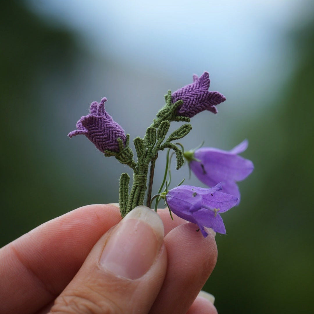 Bijou unisexe en micro macramé. Accessoire de mode inspiré de la nature et des fleurs sauvages d'été. Broche composée de deux campanules violettes avec feuille ciselée. Support de broche en laiton rhodié argenté fin avec cliquet de sécurité à tourner. Accessoire elfique, féérique pour veste, sac ou chapeau. Parfait en Boutonnière de mariage pour homme ou comme accessoires bohème pour costume et tenue de Festival. Bijou d'été poétique en 3D. Réalisé avec fil de coton de 0,3 mm vert tendre et violet.