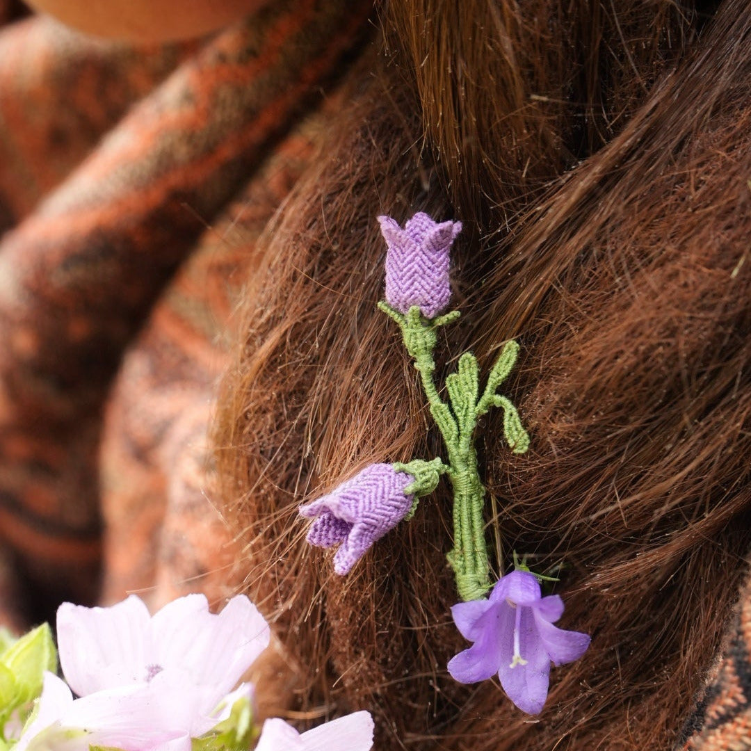 Bijou unisexe en micro macramé. Accessoire de mode inspiré de la nature et des fleurs sauvages d'été. Broche composée de deux campanules violettes avec feuille ciselée. Support de broche en laiton rhodié argenté fin avec cliquet de sécurité à tourner. Accessoire elfique, féérique pour veste, sac ou chapeau. Parfait en Boutonnière de mariage pour homme ou comme accessoires bohème pour costume et tenue de Festival. Bijou d'été poétique en 3D. Réalisé avec fil de coton de 0,3 mm vert tendre et violet.
