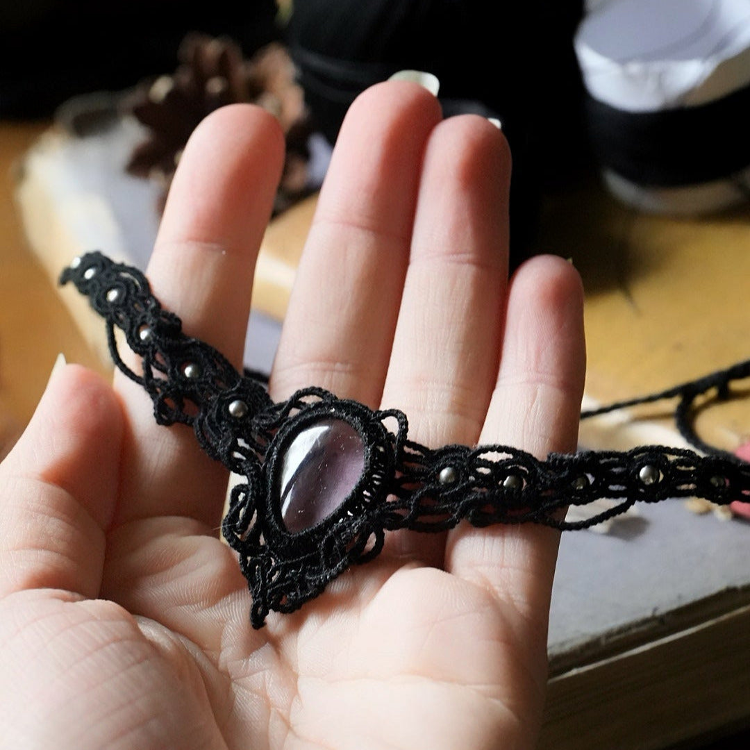 Gros plan sur fluorite rose pâle en goutte sertie en macramé noir
