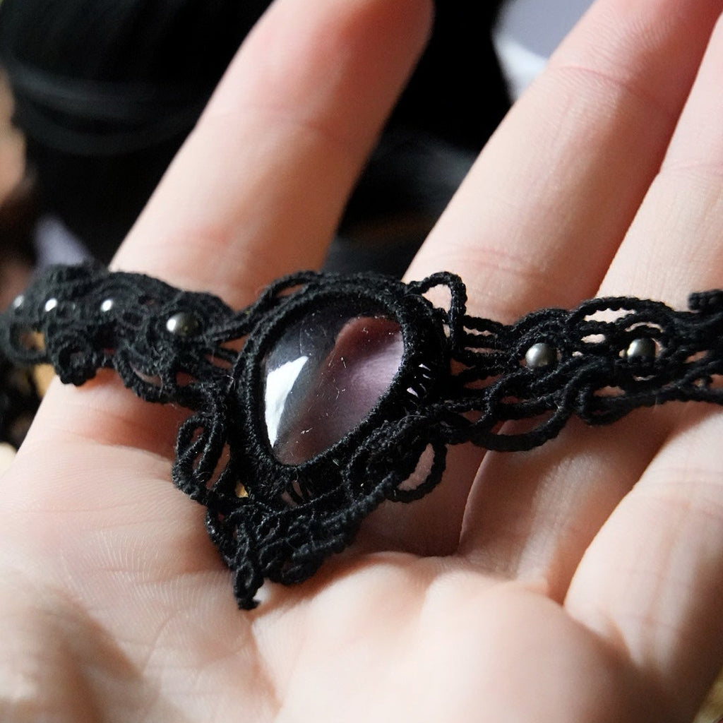 Gros plan sur fluorite rose pâle en goutte sertie en macramé noir
