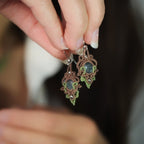Boucles d’oreilles tenues dans une main - Coton et Astrance
