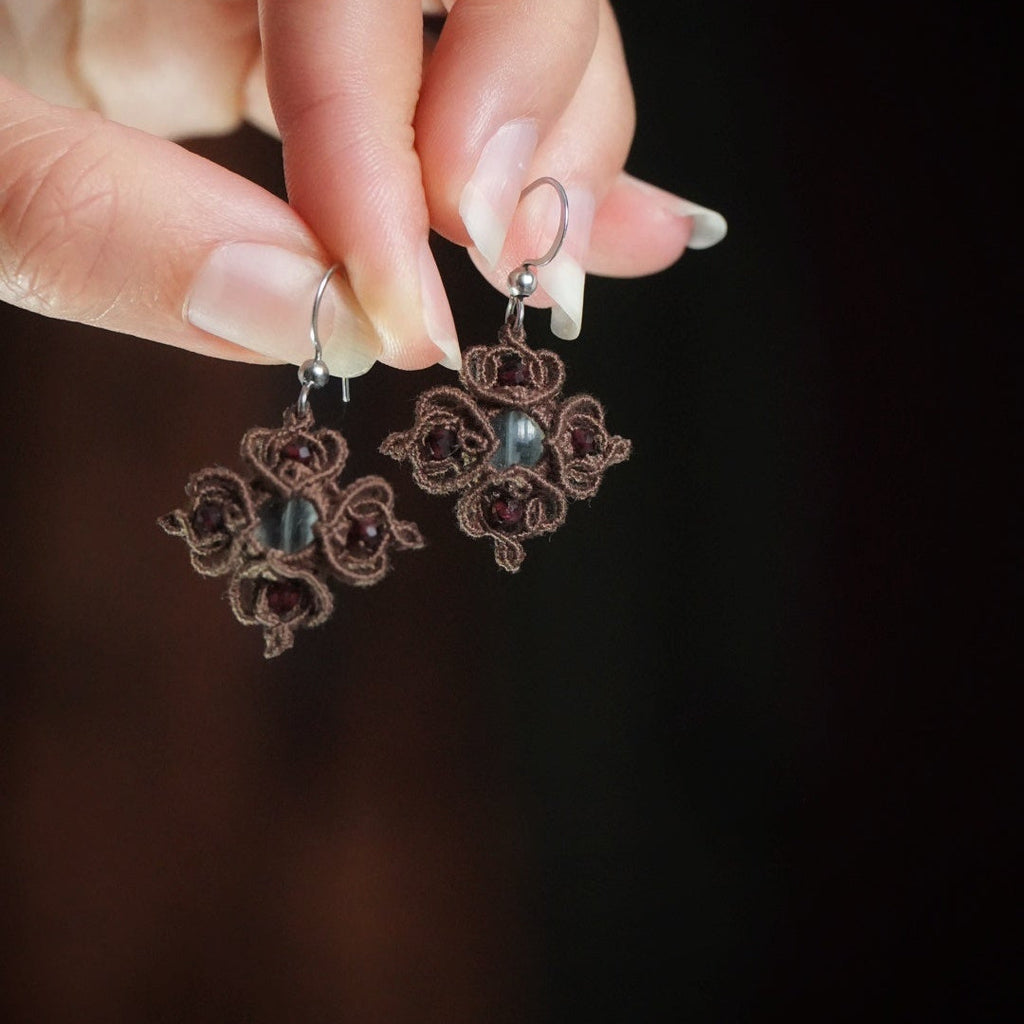 Boucles d’oreilles tenues dans une main - Coton et Astrance