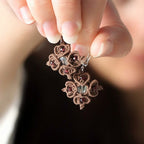 Boucles d’oreilles tenues dans une main - Coton et Astrance