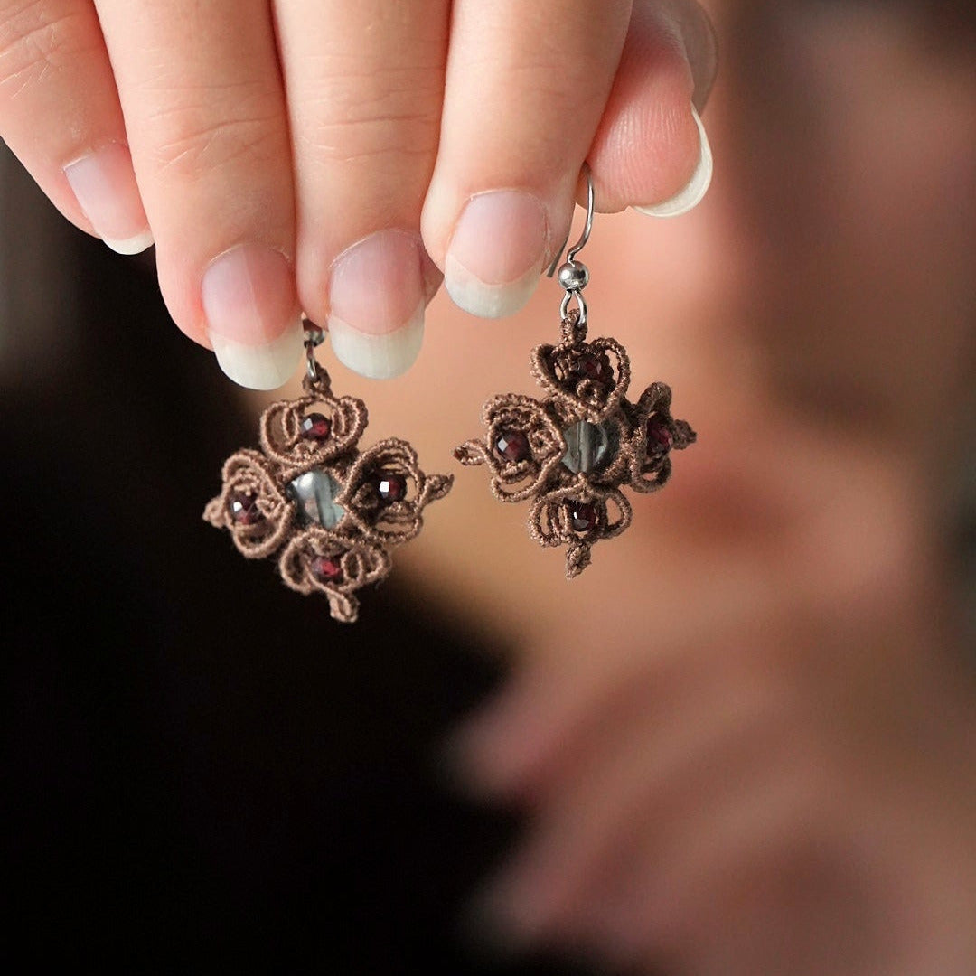 Boucles d’oreilles tenues dans une main - Coton et Astrance