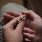 Détail du cœur opale et grenats sur fleurs tissées — Coton et Astrance