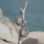 Boucles d'oreilles Trésors d'Ecume composée d'une Larimar bleu ciel ovales, mini Perles rondes en acier inoxydable argenté pour le côté luxe et précieux. Dormeuses en acier inoxydable pour un port assuré. Fil de Coton couleur lin naturel (beige gris) de 0, 5 mm tissé en micro-macramé en relief version celtique. Bijoux en vertical sur un bois flotté avec fond marin et plage, cailloux blanc et océan bleu. Ambiance sirène, plage et tropiques, bohème et hippie. Parfait pour les tenues mariage et festivals. 