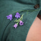 Bijou unisexe en micro macramé. Accessoire de mode inspiré de la nature et des fleurs sauvages d'été. Broche composée de deux campanules violettes avec feuille ciselée. Support de broche en laiton rhodié argenté fin avec cliquet de sécurité à tourner. Accessoire elfique, féérique pour veste, sac ou chapeau. Parfait en Boutonnière de mariage pour homme ou comme accessoires bohème pour costume et tenue de Festival. Bijou d'été poétique en 3D. Réalisé avec fil de coton de 0,3 mm vert tendre et violet. 