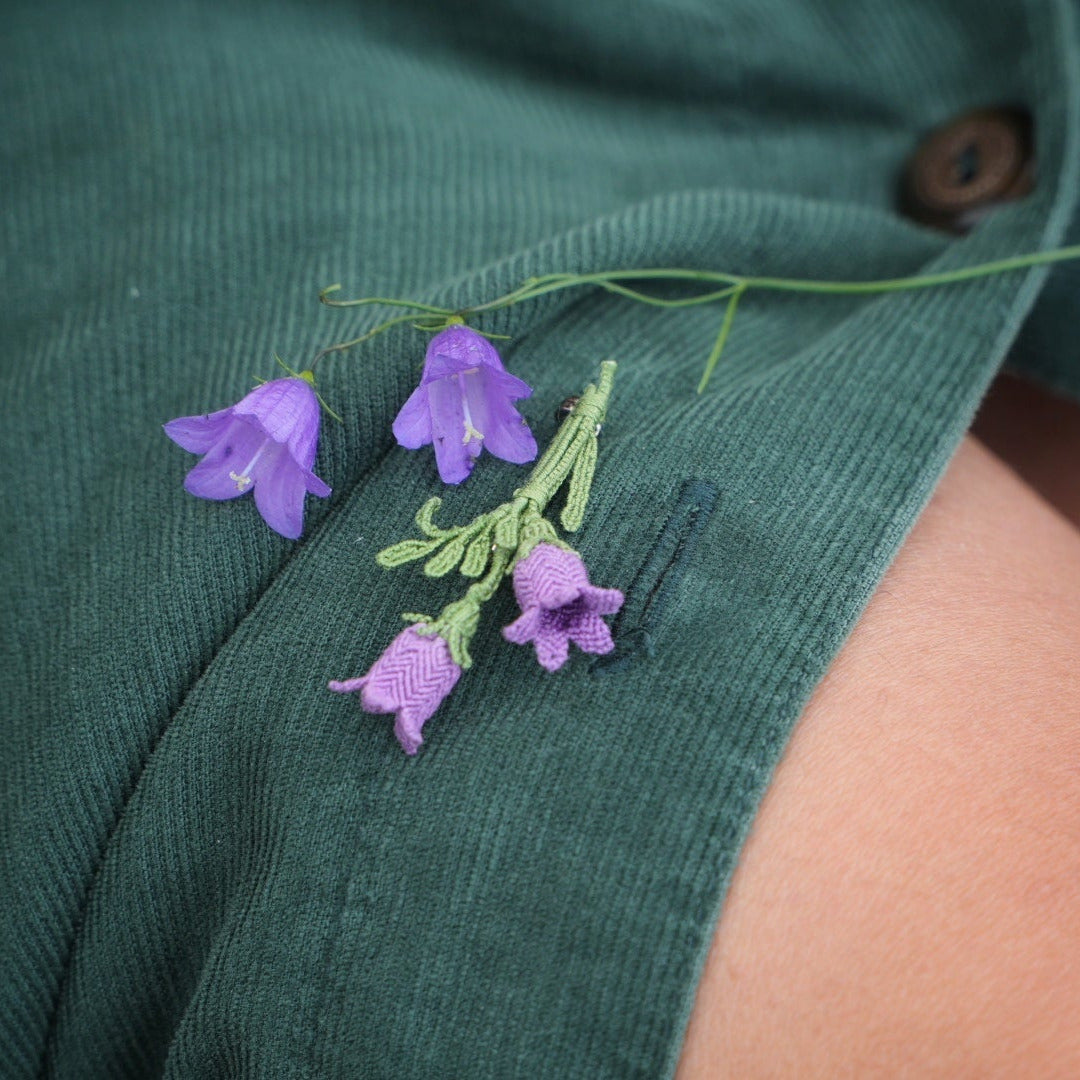 Bijou unisexe en micro macramé. Accessoire de mode inspiré de la nature et des fleurs sauvages d'été. Broche composée de deux campanules violettes avec feuille ciselée. Support de broche en laiton rhodié argenté fin avec cliquet de sécurité à tourner. Accessoire elfique, féérique pour veste, sac ou chapeau. Parfait en Boutonnière de mariage pour homme ou comme accessoires bohème pour costume et tenue de Festival. Bijou d'été poétique en 3D. Réalisé avec fil de coton de 0,3 mm vert tendre et violet. 