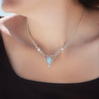 Collier ras-de-cou forme v Trésors d'Ecume composée d'une Larimar bleu ciel en poire pointe en bas, perles en nacre blanche ronde rappel des coquillages et de la plage, mini Perles rondes en acier inoxydable argenté pour le côté luxe et précieux. Fil de Coton couleur lin naturel (beige gris) de 0, 5 mm tissé en micro-macramé en relief version celtique. Collage 3 photos : Bijoux porté sur une femme bronzée et brune avec débardeur marron foncé. Photo ambiance tropiques et plages, style bohème hippie 