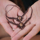Bijoux de pieds, paire assortie de bracelets de chevilles à ambiance bohème celtique elfique. Fil marron foncé fin tissé en micro macramé avec entrelacs et arabesques, pierre centrale ovale petite taille jaune miel translucide. Bijoux hippie, bohème avec inspiration nature. Chevillères posées à plat dans 2 mains en coupe à la peau pâle, un bijou au dessus de l'autre