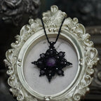 Bijou elfique sombre en micro macramé noir, pendentif étoile lumineux photographié sur fond gothique romantique. Coton et Astrance